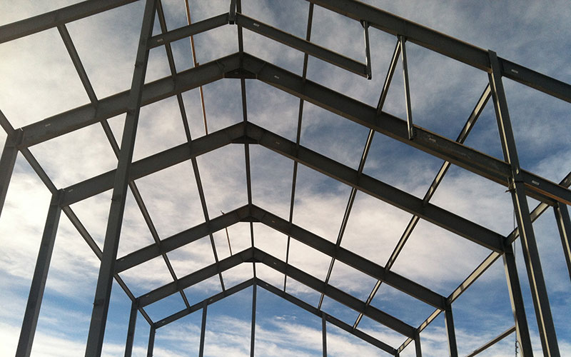 metal bars forming a pointed roof against a blue sky